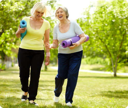 Two women enjoying a walk with yoga mats