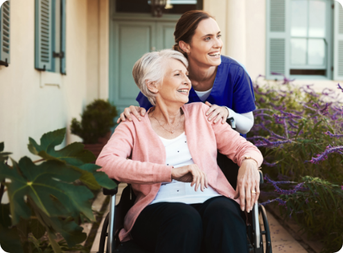 Caregiver assisting smiling resident outdoors