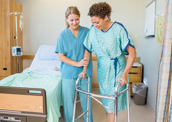 A staff member assisting a resident with a walker.