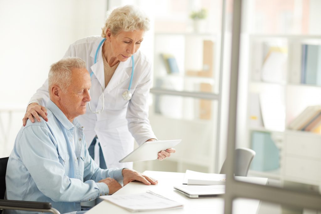 Healthcare professional assisting an elderly man