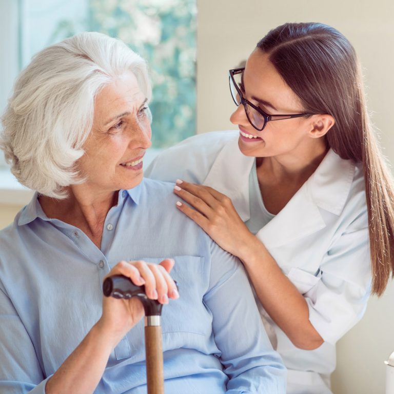 Nurse interacting with senior resident in a caring manner.