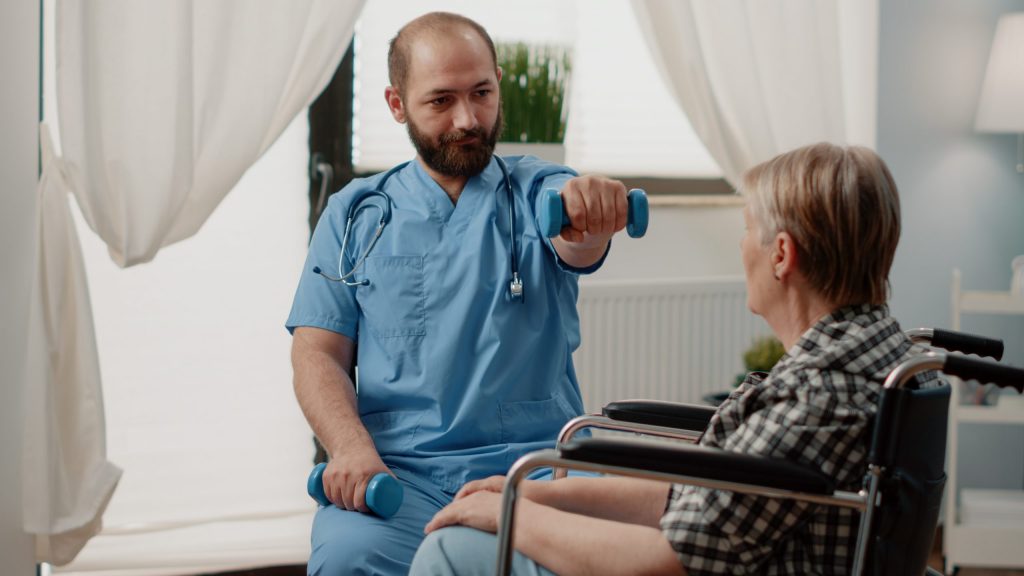 Therapist assisting a resident with arm exercise.