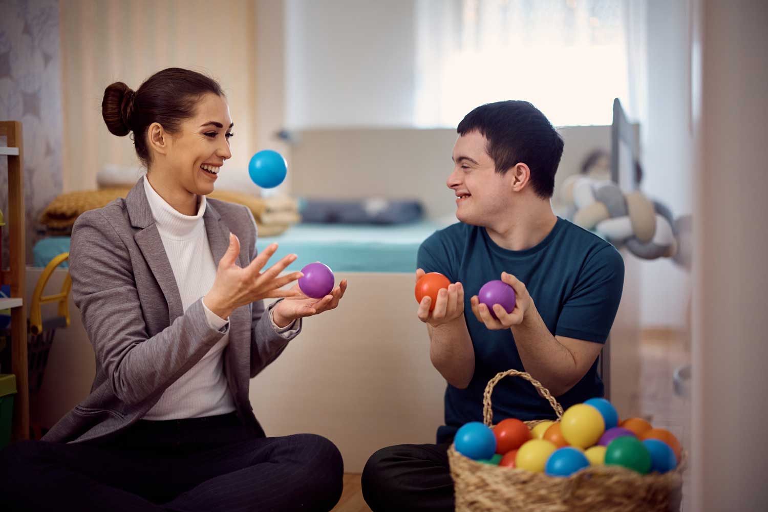 Therapist and client playing with colorful balls.