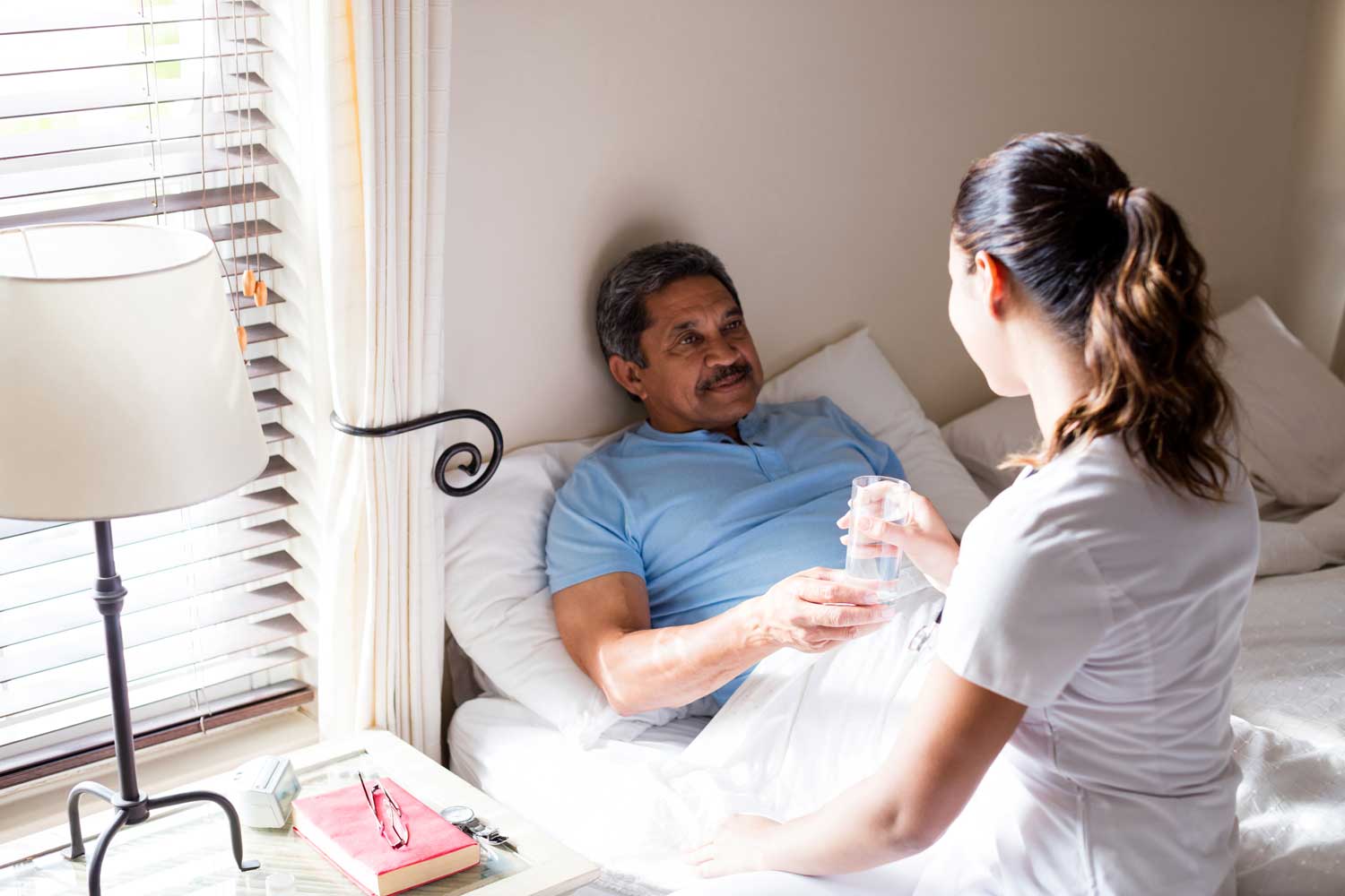 Caregiver assisting a resident with water