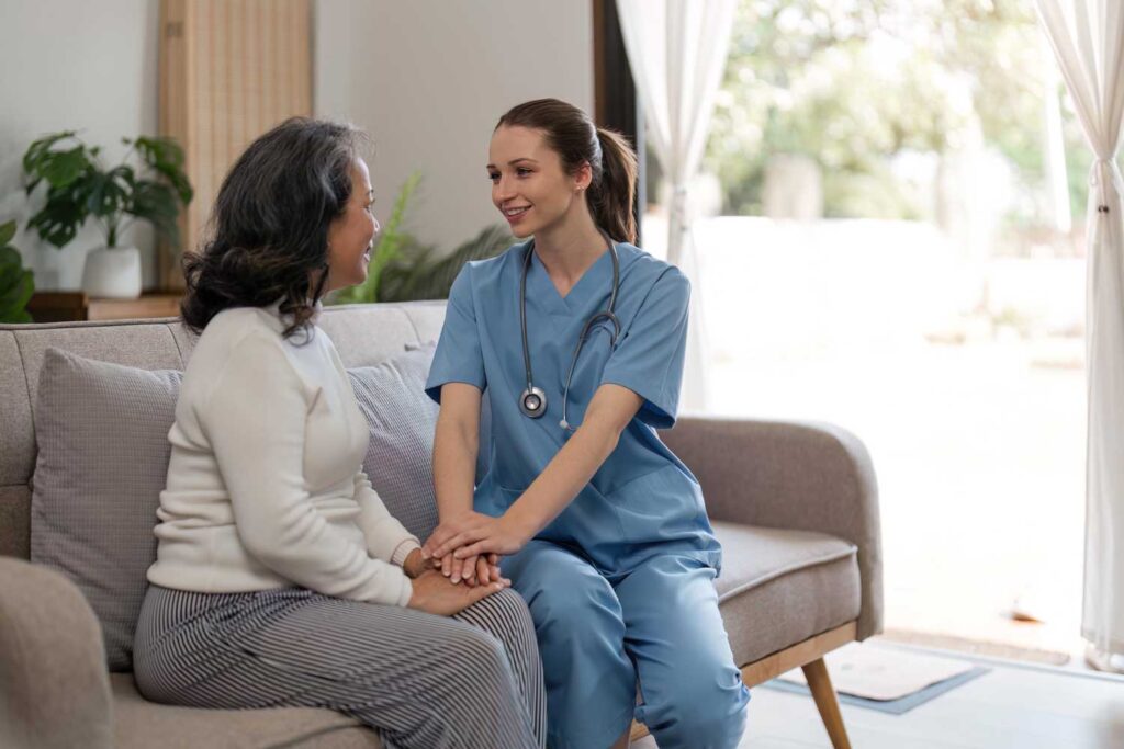 Nurse smiling and holding hands with resident