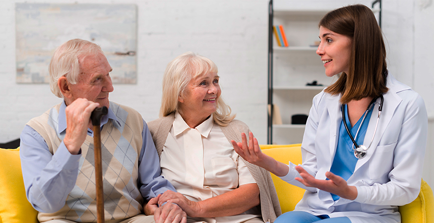 Healthcare professional interacting with senior couple.