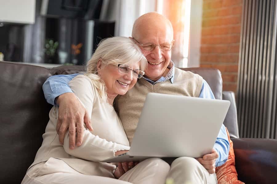 Happy elderly couple using a laptop together.