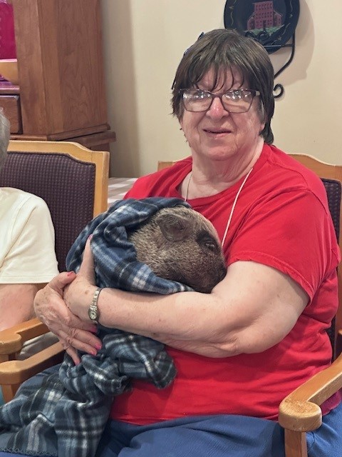 Resident cuddling a pet in a common area.