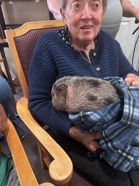 Resident holding a pet in a cozy setting.