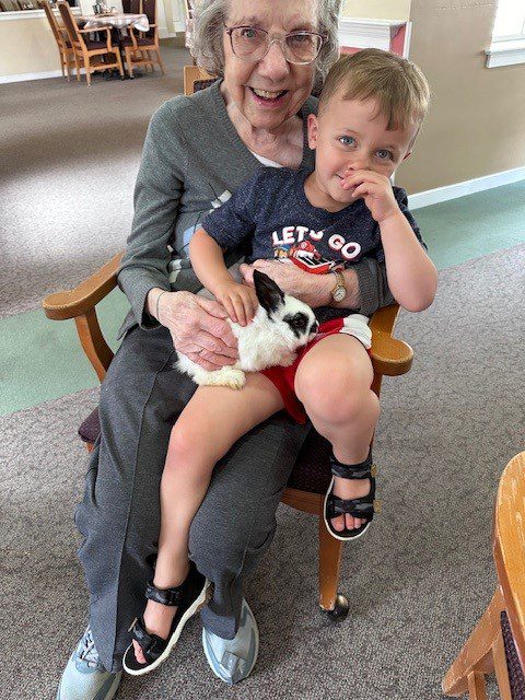 Senior resident with child holding a rabbit