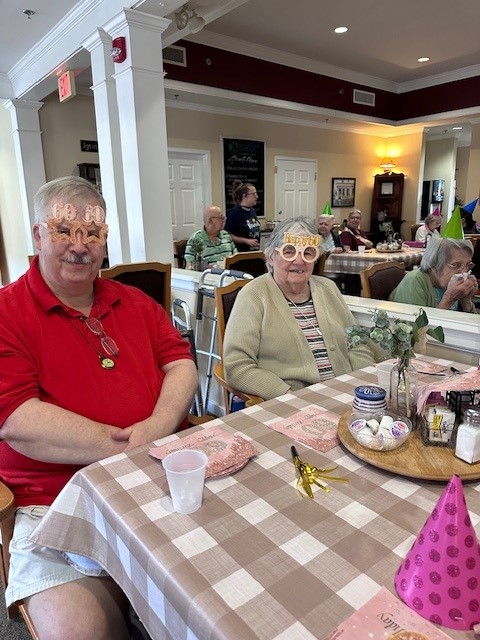 Residents enjoying a festive celebration with fun glasses.