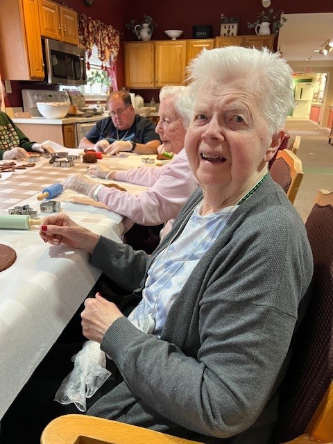 Residents engaged in a baking activity in the dining area.