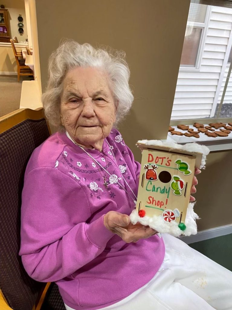 Resident proudly holding a decorated candy shop model.