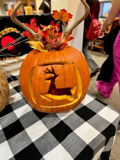 Pumpkin decoration with autumn leaves and antlers.