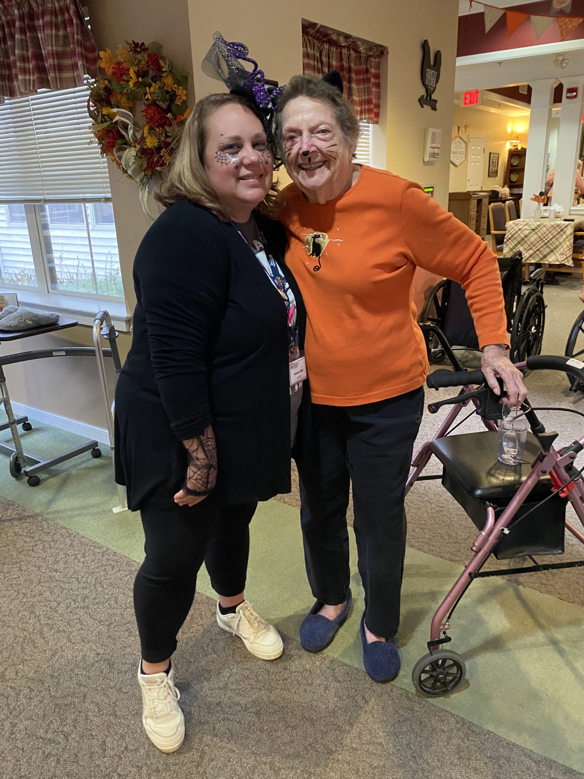 Staff member posing with a resident in a common area.