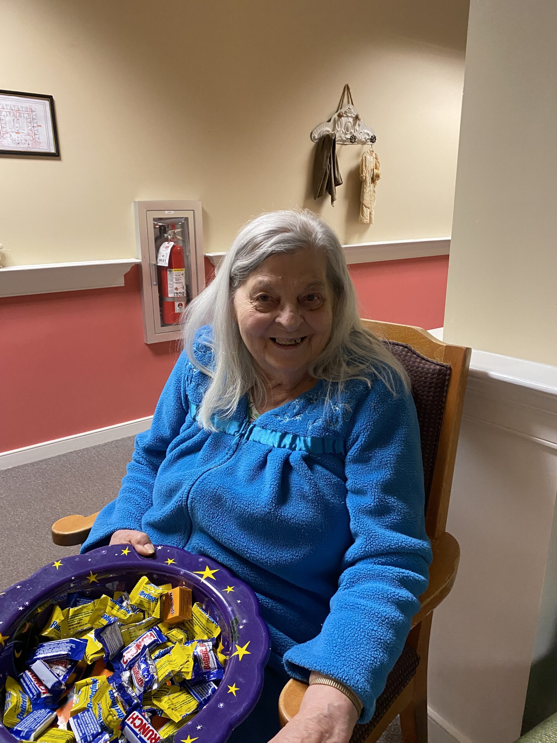 Senior woman smiling with a bowl of candy