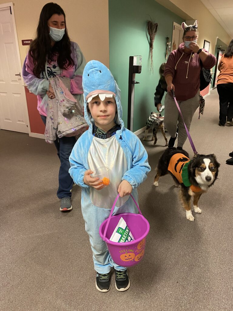Children and pets in costumes during an indoor event