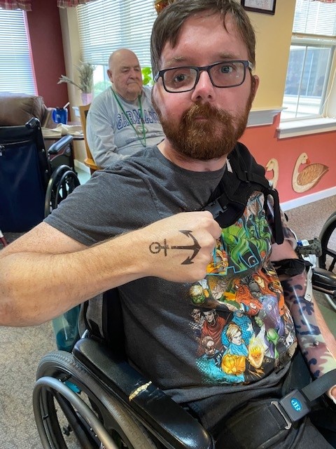 A resident showing a tattoo in a common area.