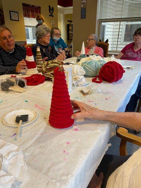 Residents engaged in a crafting activity at a table.