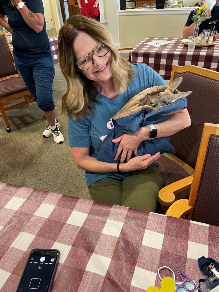 Resident holding a pet in a cozy indoor setting
