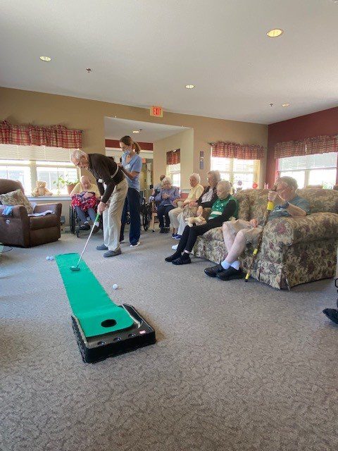 Residents participating in an indoor putting activity.
