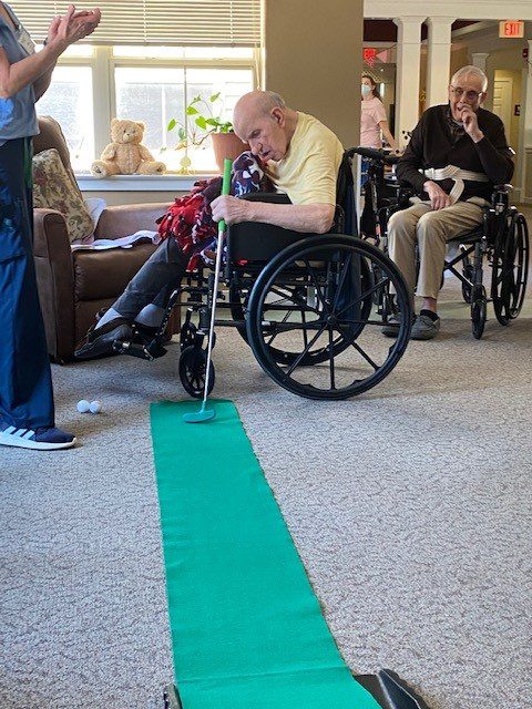 Residents participating in a golf activity indoors