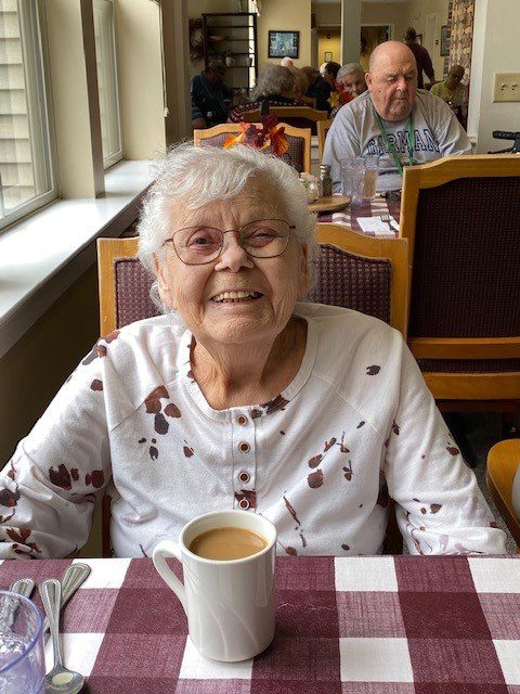 Smiling resident enjoying coffee in dining area