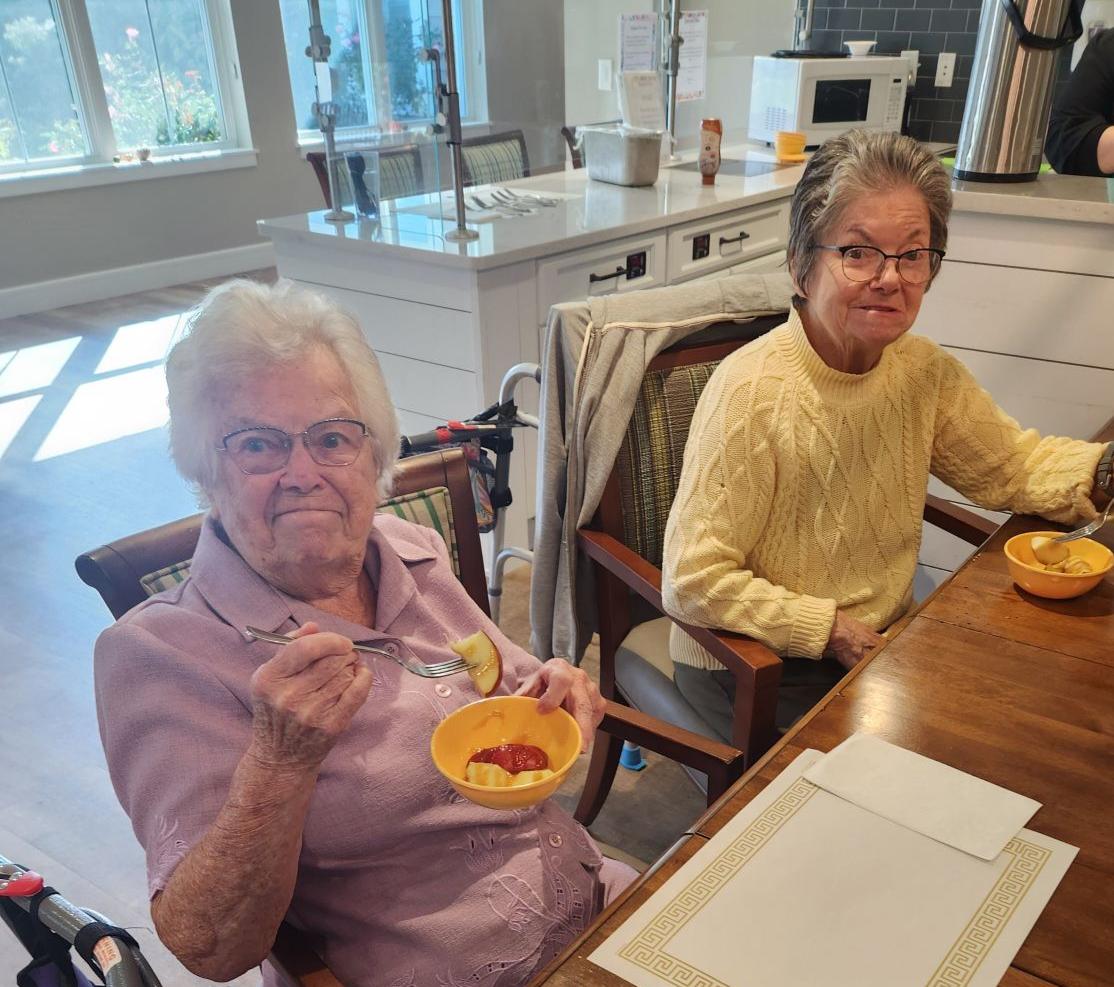 Two residents enjoying dessert in the dining area