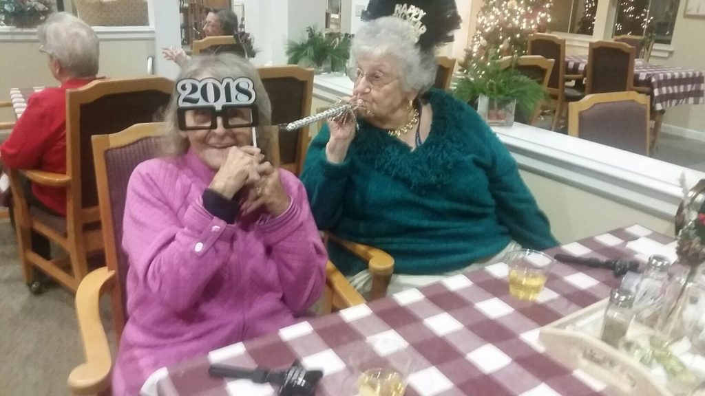 Two residents celebrating New Year's with props.