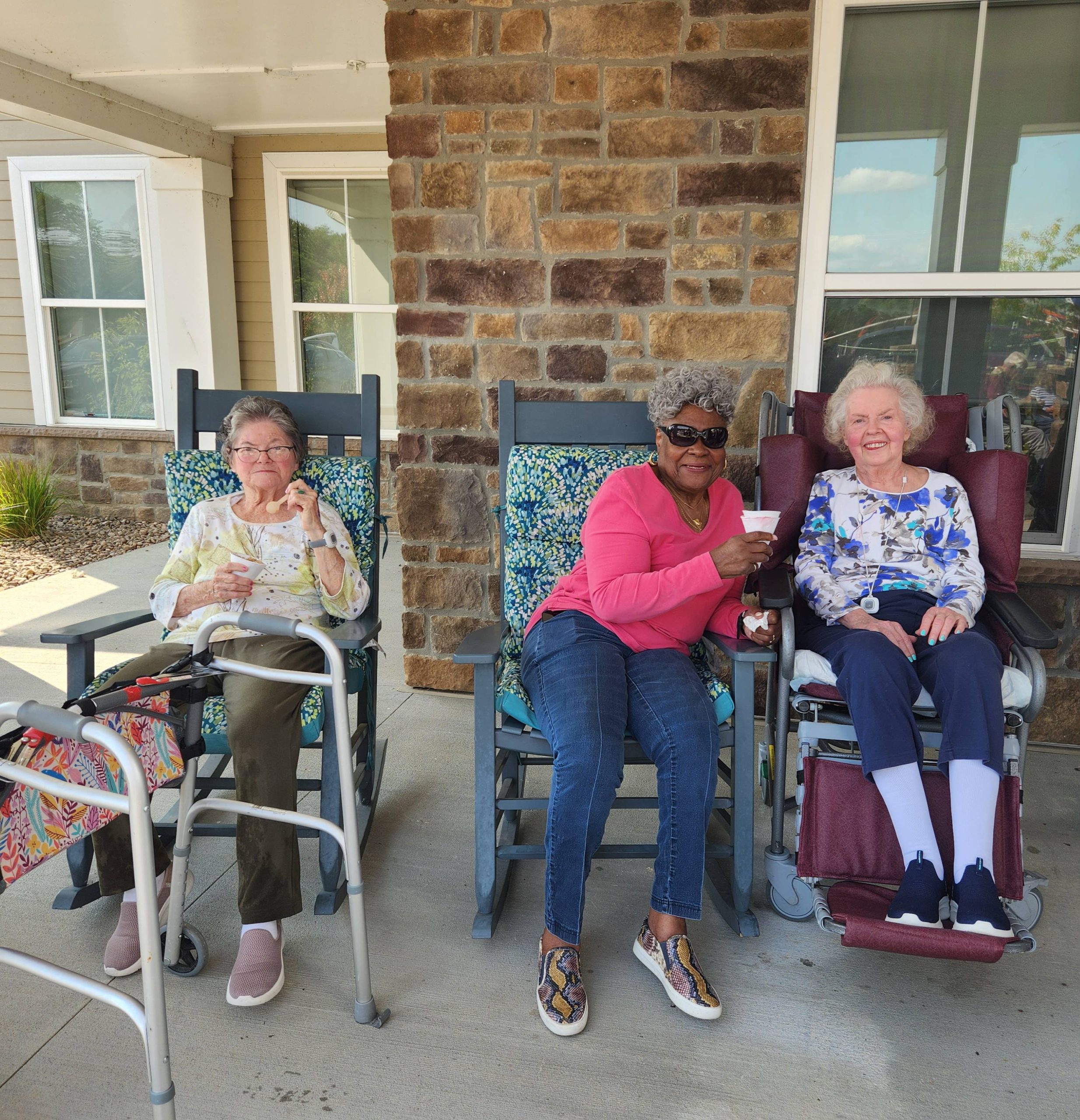 Three residents enjoying treats on a porch.