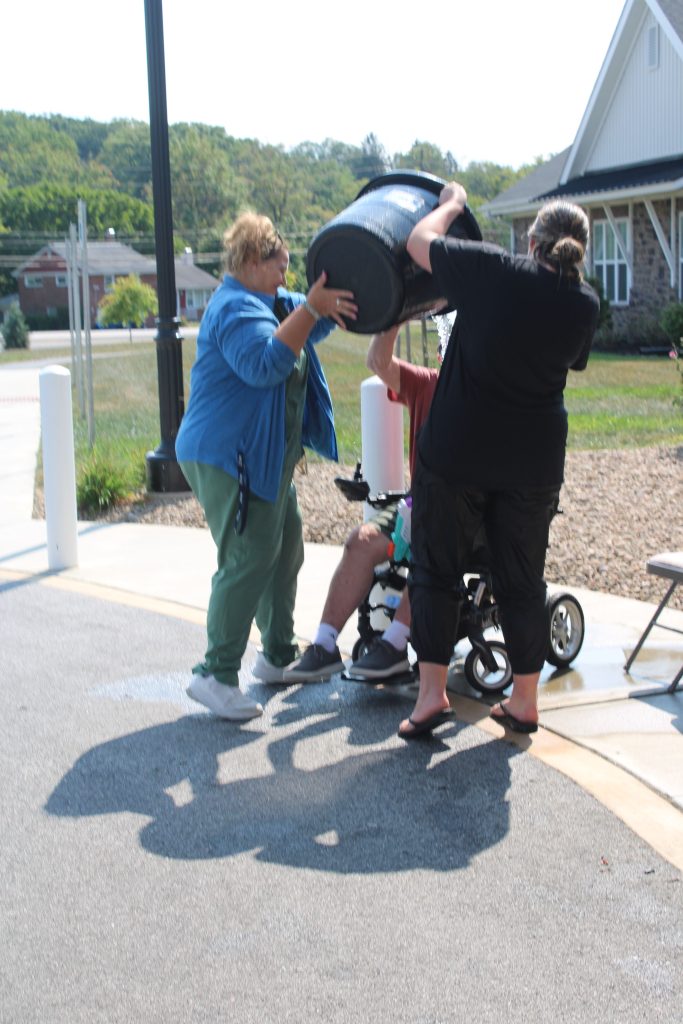 Staff assisting a resident outdoors.