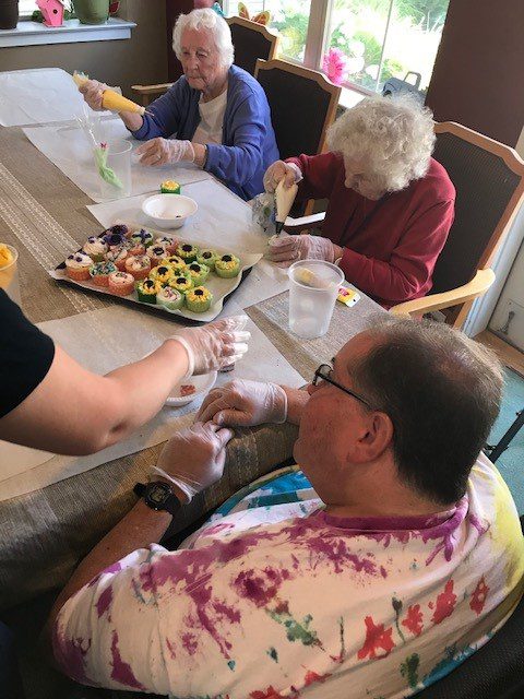 Residents decorating cupcakes in a communal activity