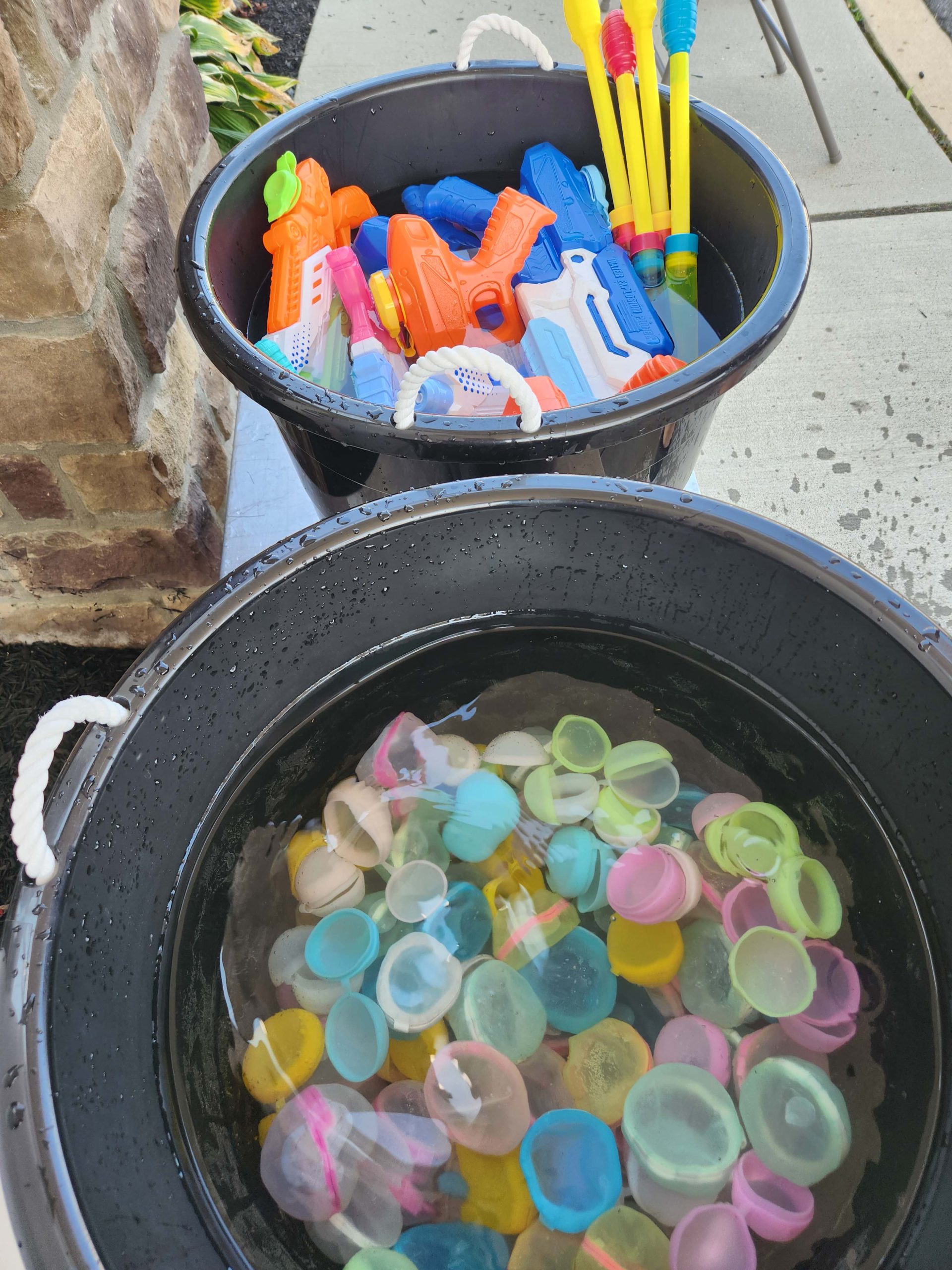 Buckets filled with water toys at an outdoor area
