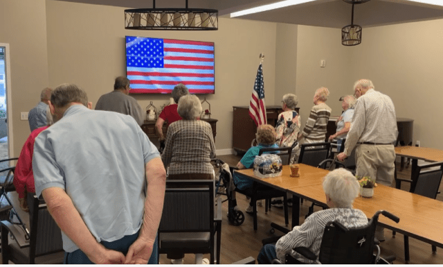 Residents engaged in an indoor activity with an American flag display.