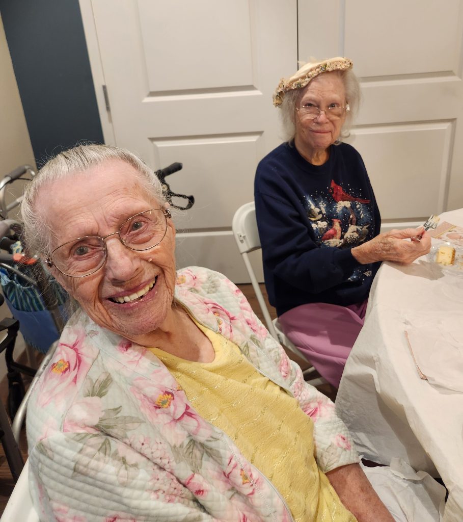 Two elderly women smiling at a table