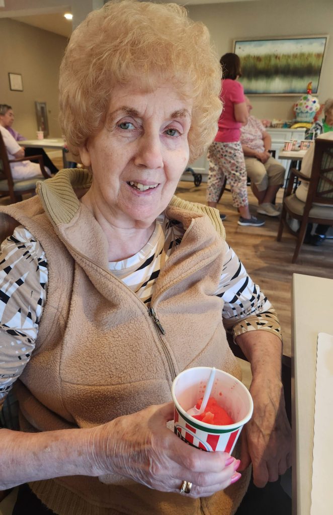 Senior woman enjoying a treat in the facility's common area.