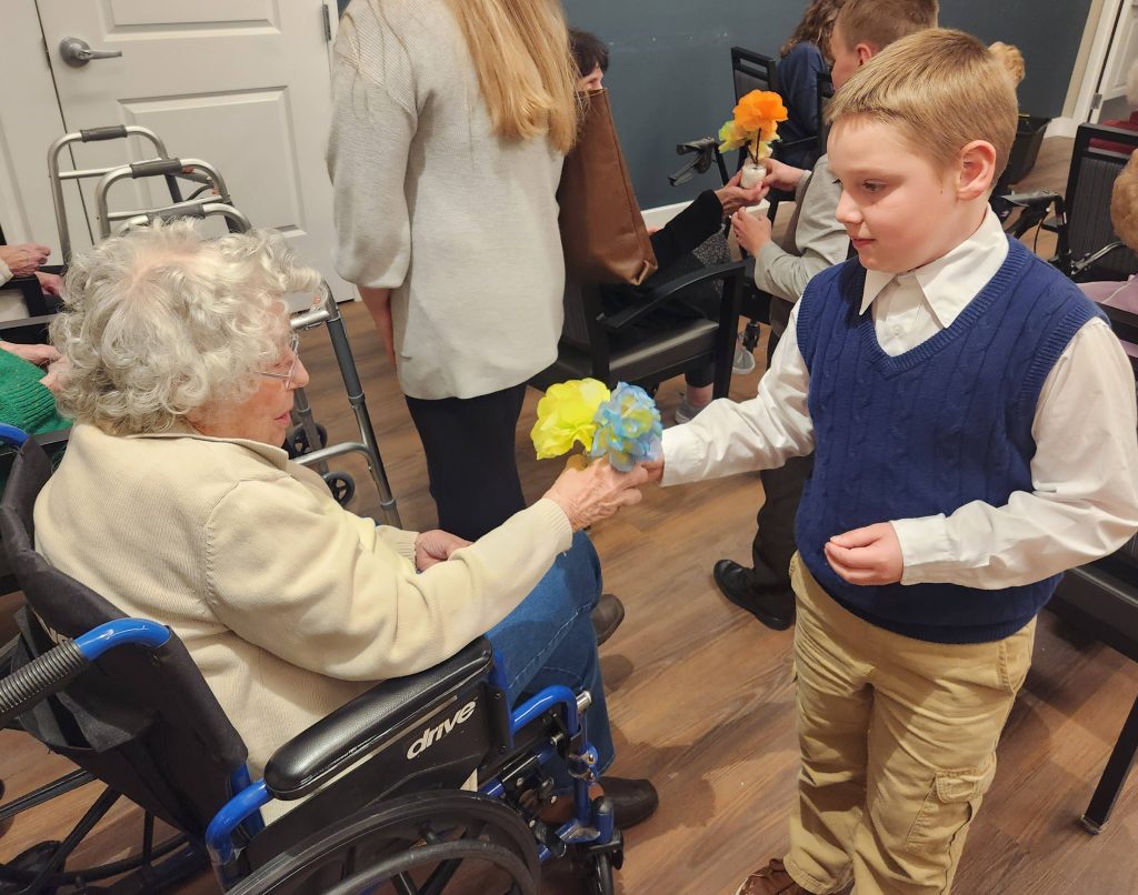 Resident receiving a flower from a child