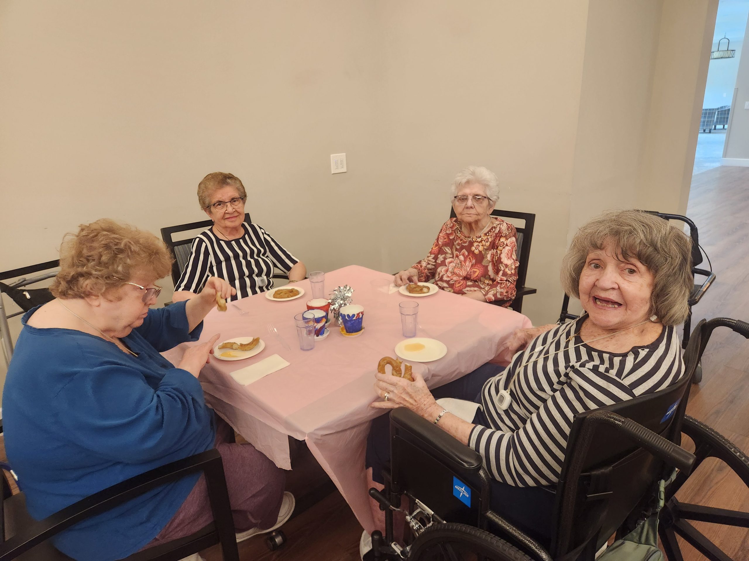 Four residents enjoying snacks together at a table.