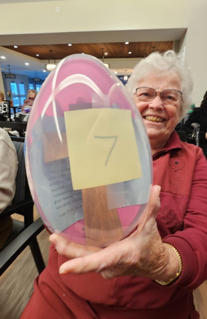 Resident holding a colorful Easter egg during an activity
