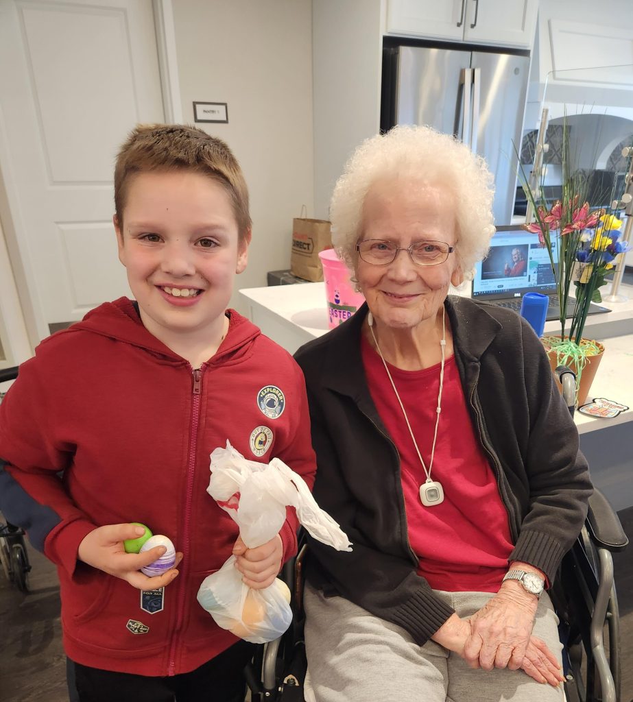 A resident and a boy smiling together indoors.