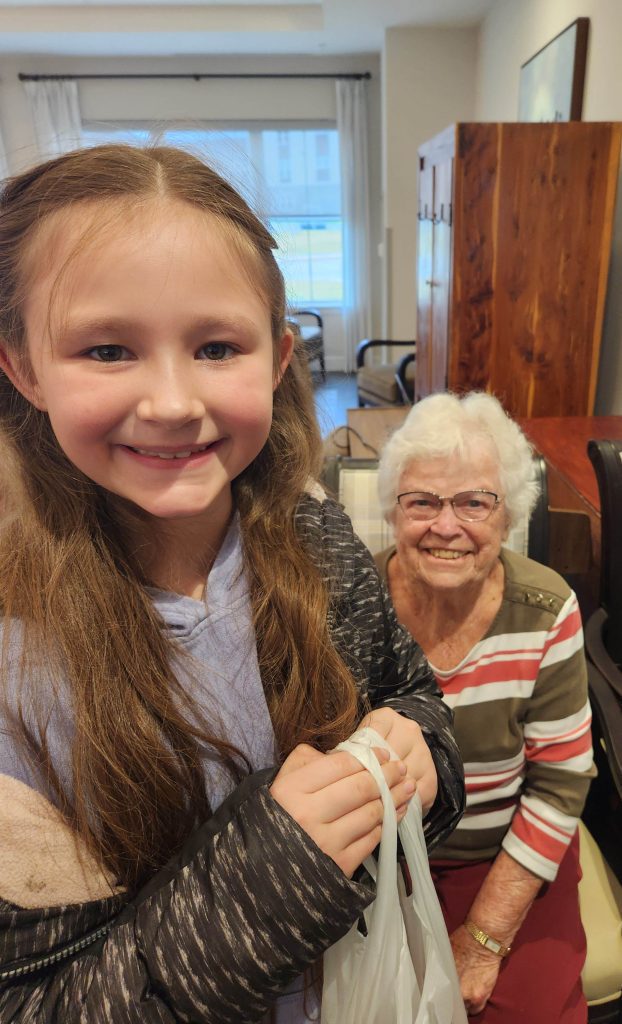 A young girl smiling with an elderly resident