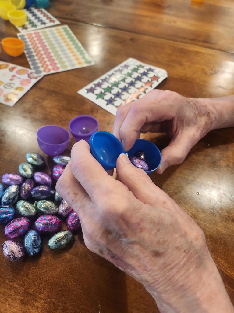Hands decorating eggs during an activity.
