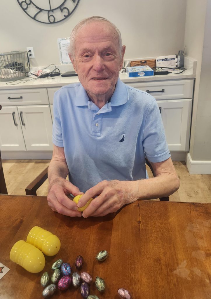 Resident enjoying a festive activity with colorful eggs.