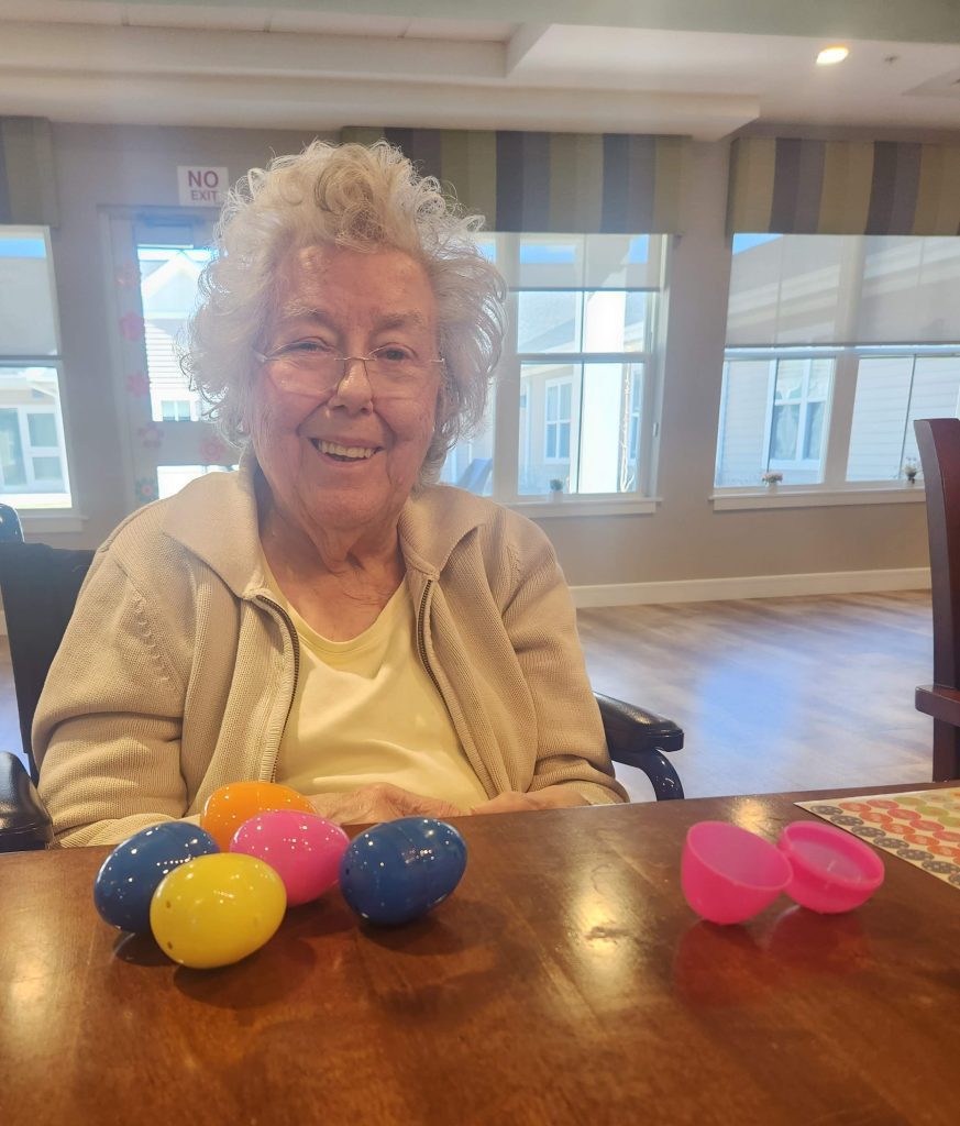 Senior resident enjoying Easter activities with colored eggs.