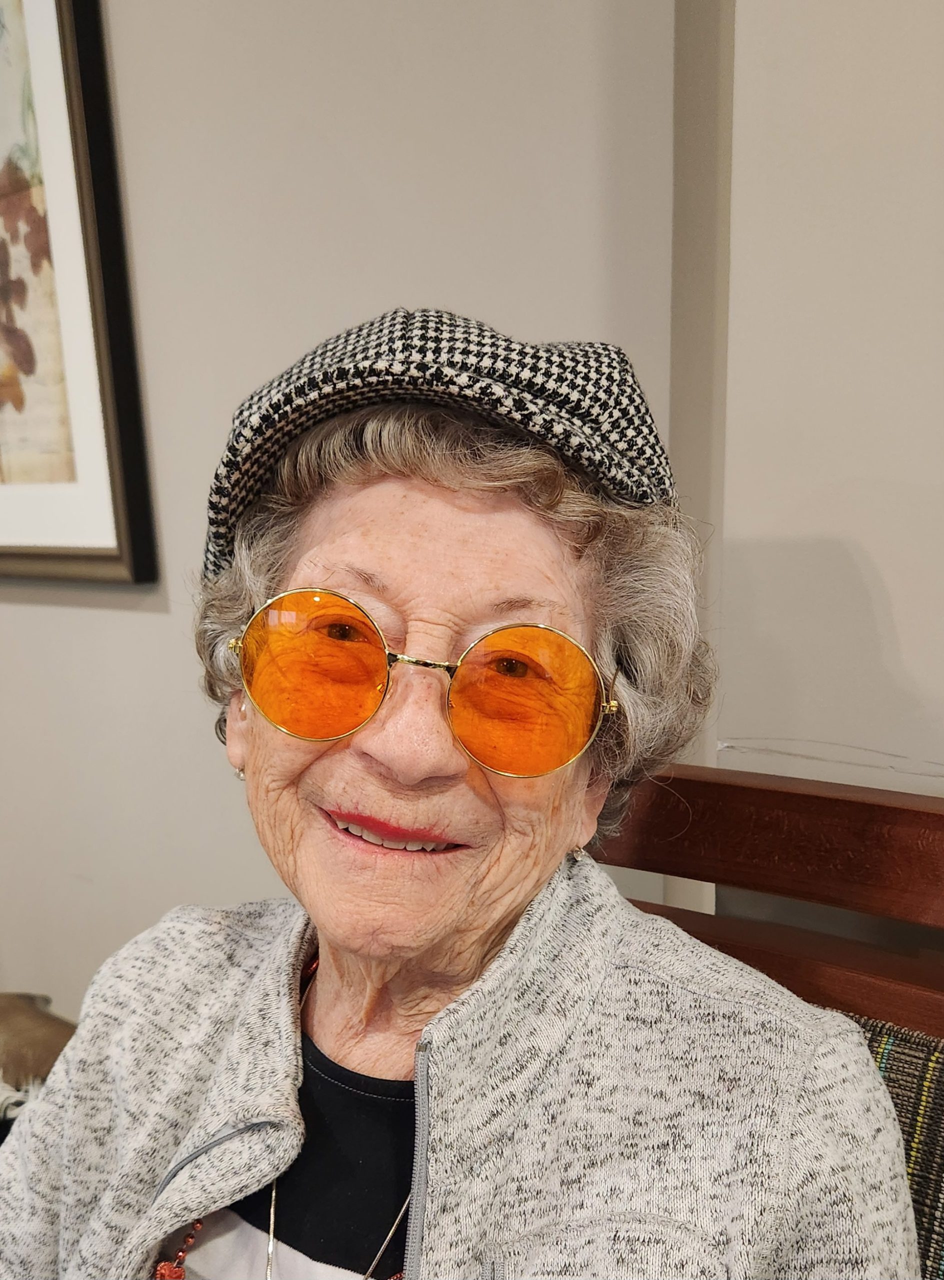 Elderly woman with orange sunglasses and a hat.