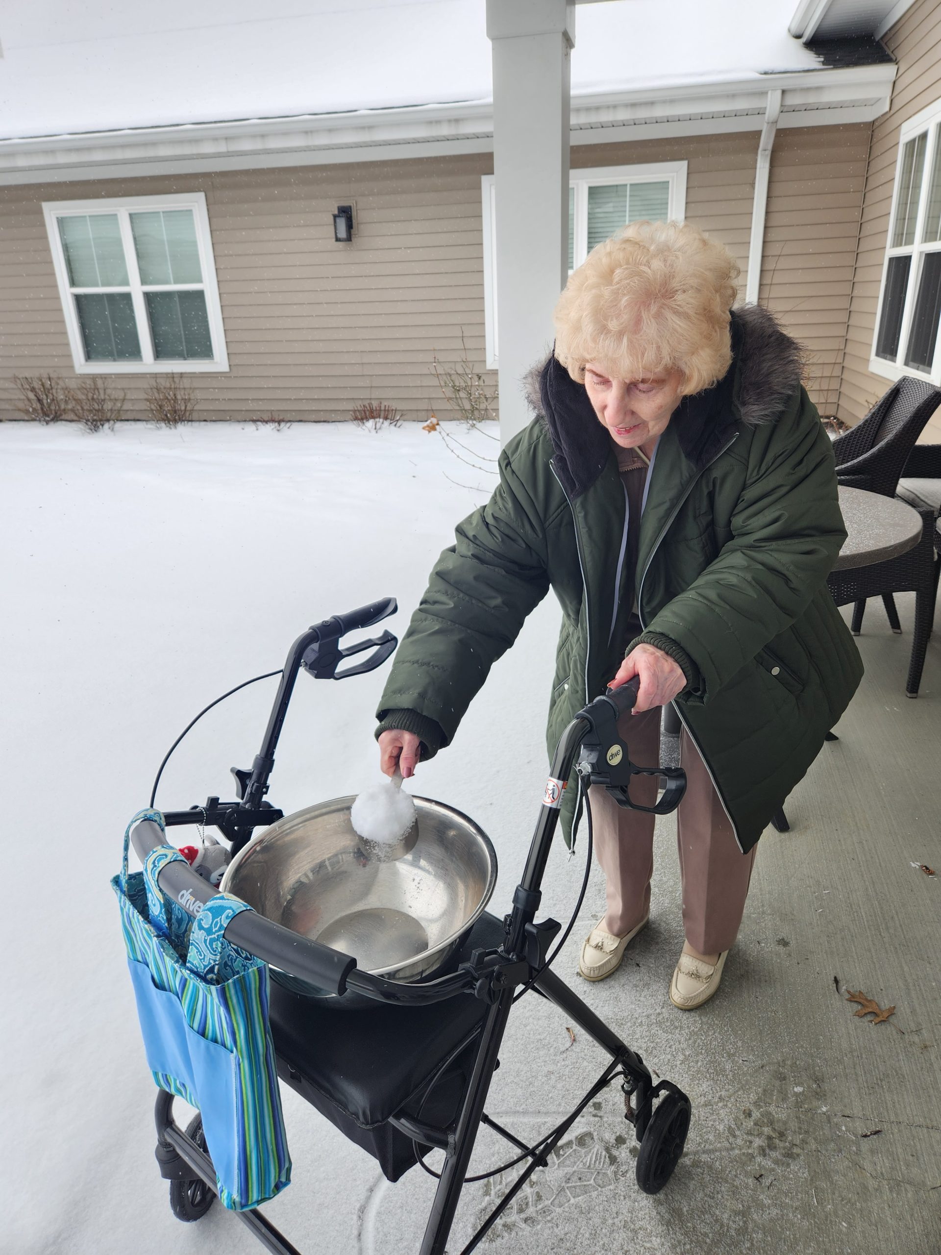 Senior woman playing with snow outside.