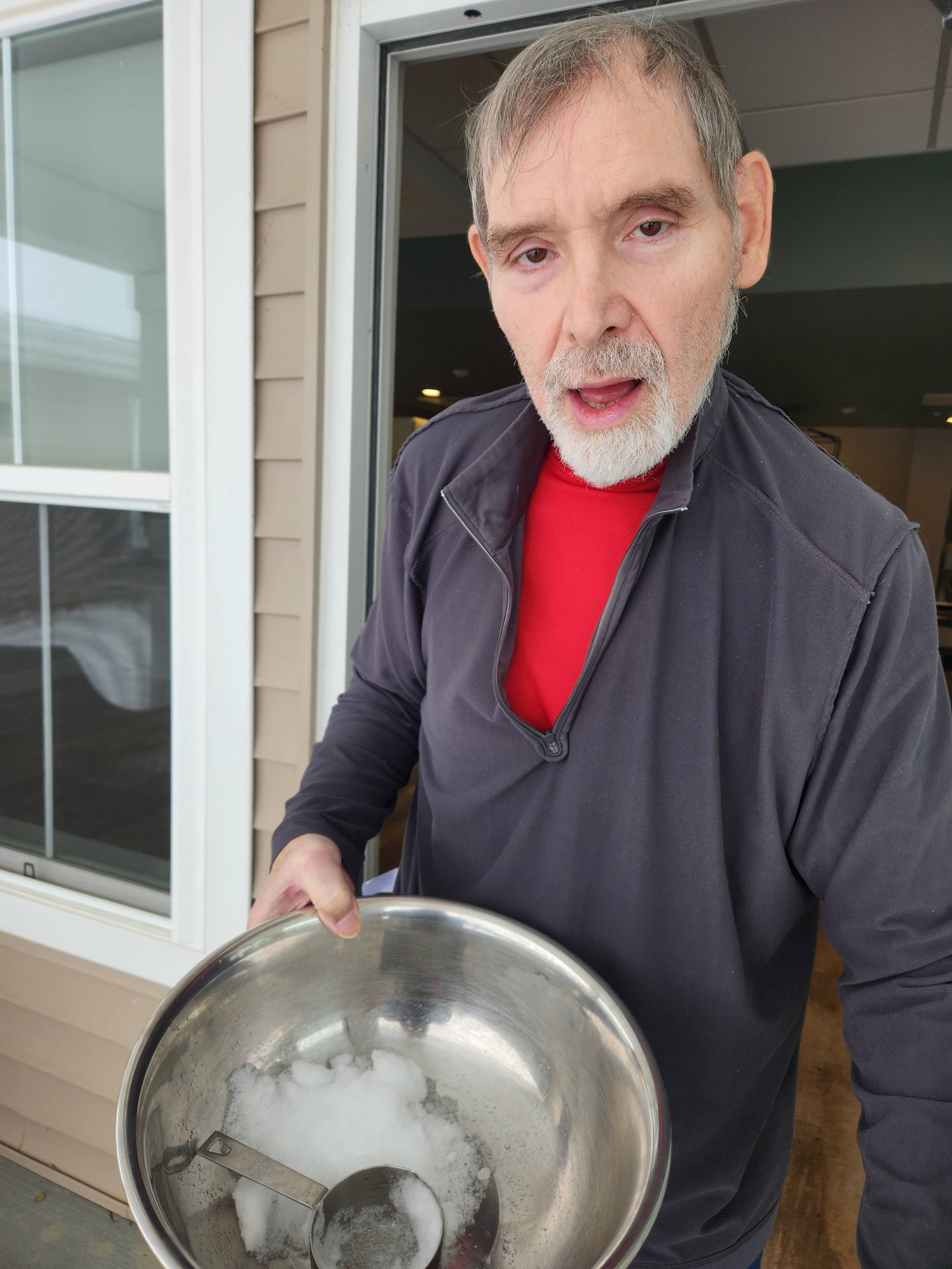 Resident preparing a snowy activity outdoors.