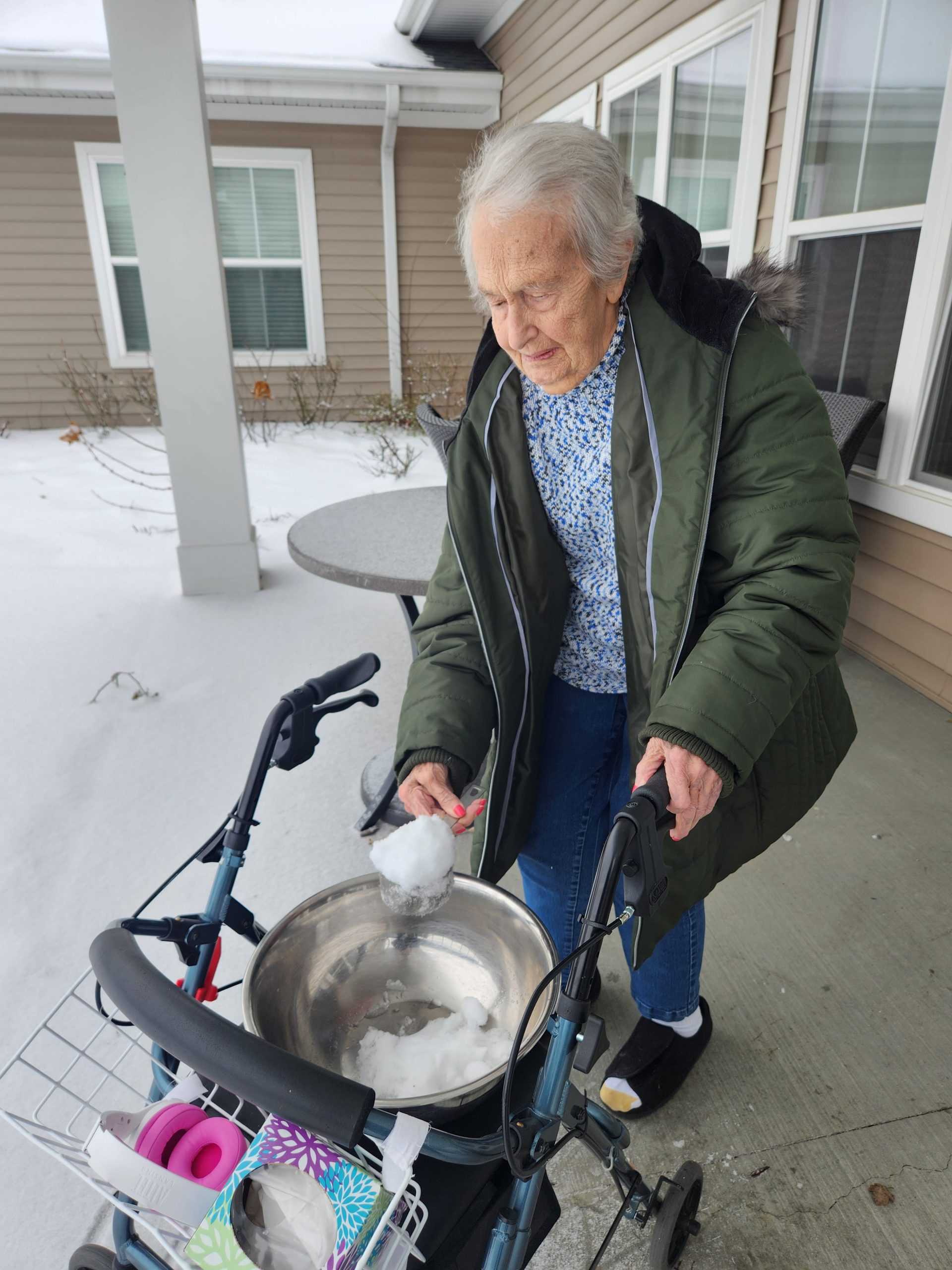 Resident enjoying snow outside with a walker.