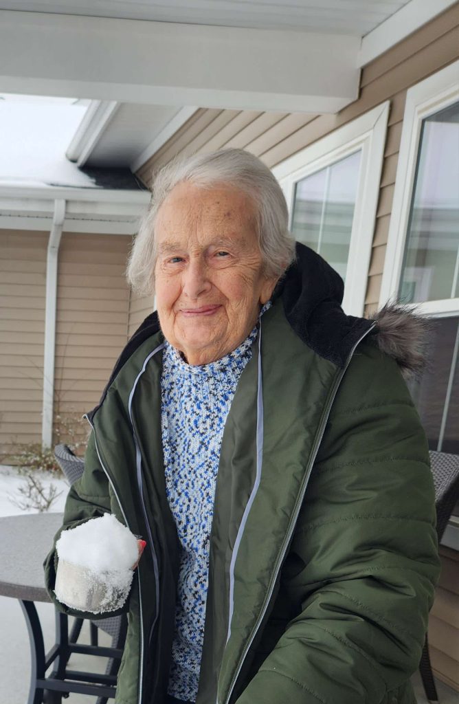 Resident enjoying snow outdoors on a patio