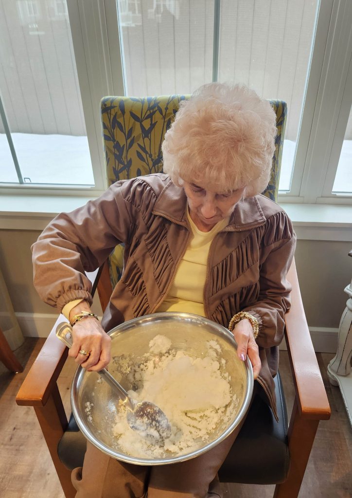 Senior resident preparing food in a common area.